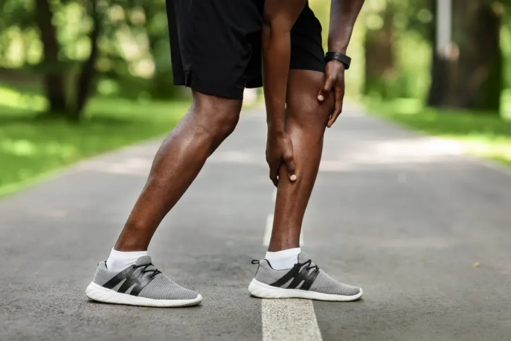 Older man stopping on a walk with calf pain, a common symptom of peripheral artery disease