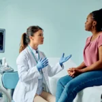 Woman discussing uterine fibroid symptoms with a physician in an ultrasound exam room