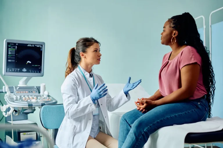Woman discussing uterine fibroid symptoms with a physician in an ultrasound exam room